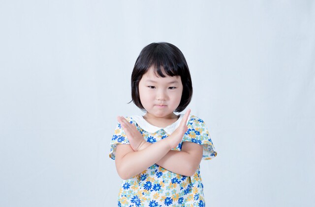 バツ印を作る女の子