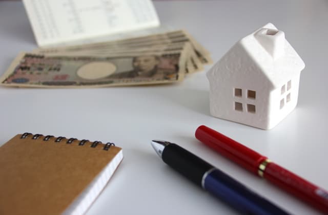 家の模型とお金とボールペン