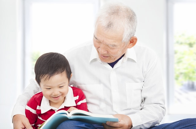 孫に本を読む男性