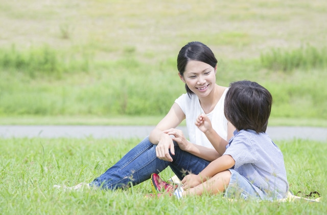 芝生でのんびりする母と息子