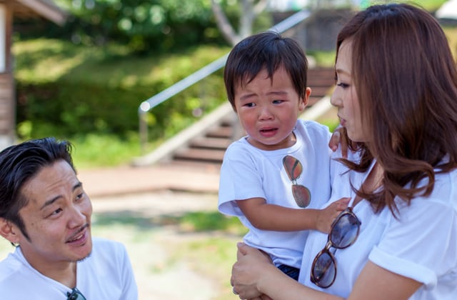 泣いている子どもを抱っこする母親