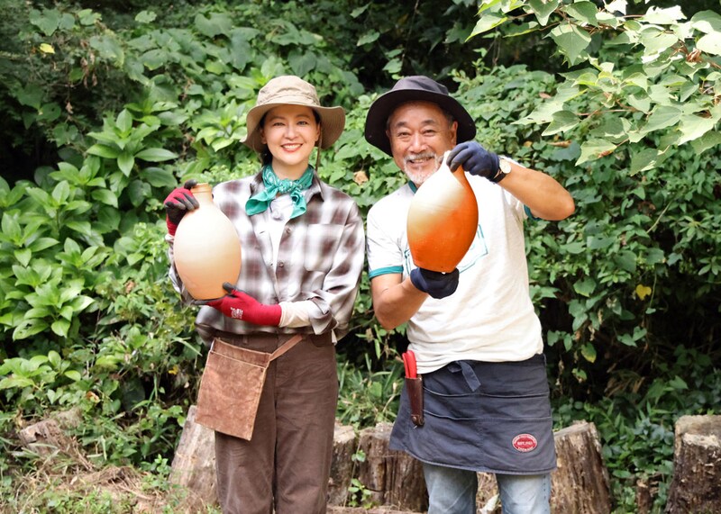 シェードガーデンの水不足を灌漑ポットで解消作戦。吉田さんが持っているほうには水が入れてあり、水がじわじわ浸み出してポットの色が濃くなっている。