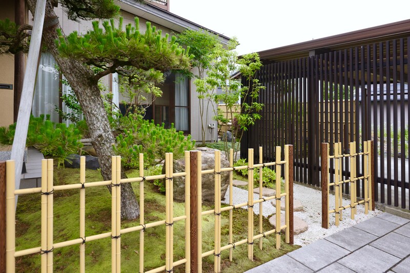 駐車場のこげ茶色の立て格子で手前の四ツ目垣根が引き立つ