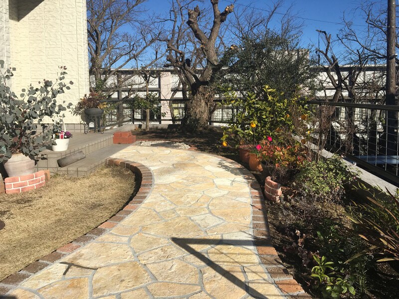 玄関扉へ続くアプローチは乱形石張りで。