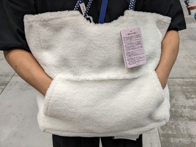 ボアポケット大型ロープハンドルリバーシブルトートのポケットに手を入れている