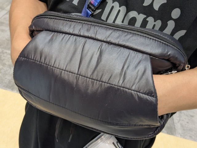 撥水・中綿ミニショルダーバッグアソートのポケットに手を入れている