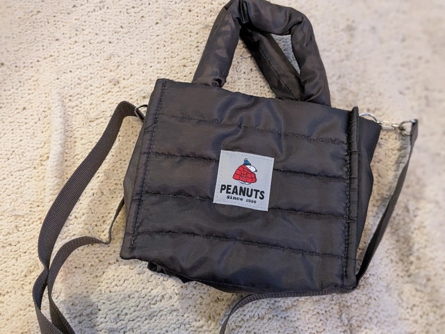 バッグ背面のPEANUTSタグ。赤いダウンジャケット姿のスヌーピーがワンポイント