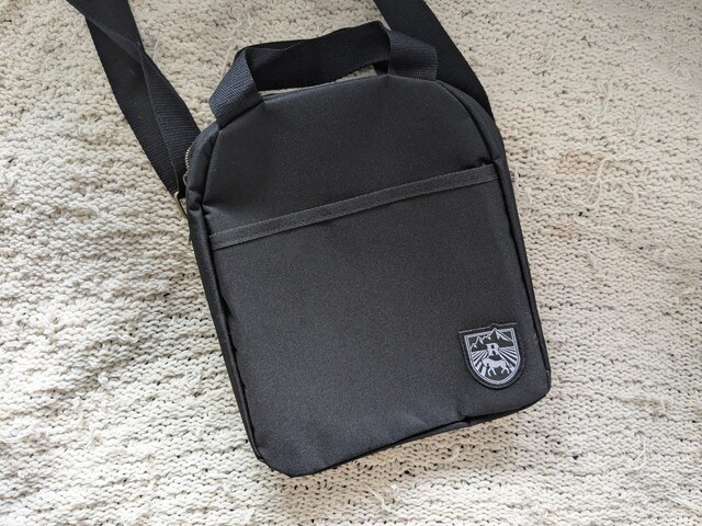 ショルダーバッグのフロント全体。シンプルなブラックにリゾナーレのロゴワッペン