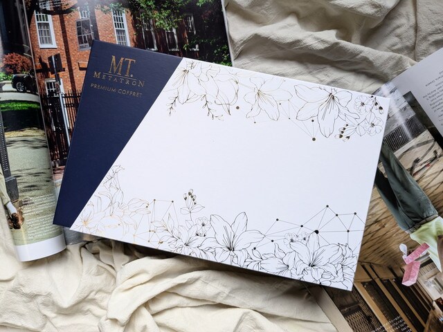 MTメタトロン プレミアムコフレ2025の外箱。白地にフラワーモチーフとネイビーのロゴボックスデザイン