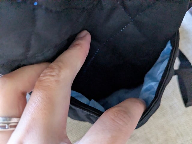 mozキルティングバックパックのサイドポケットに手を入れている様子