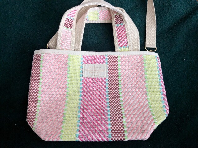 淡いピンク系ストライプと生成りの持ち手が上品なトート全体