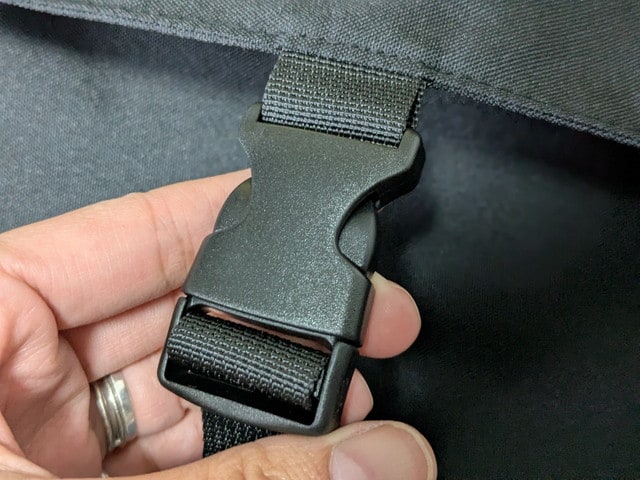 バッグのバックル部分アップ。黒いプラスチックのワンタッチバックルがついている