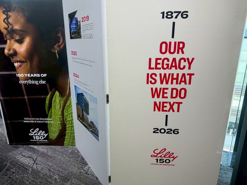 リリー創立150周年の展示パネル。「1876 OUR LEGACY IS WHAT WE DO NEXT 2026」のメッセージと150 YEARS OF MEDICINEのロゴ