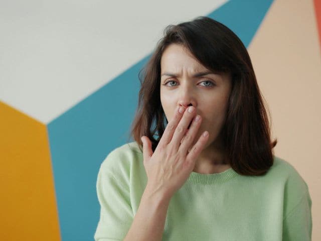 口を抑える女性