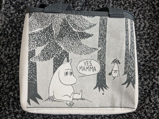 ムーミン保冷バッグの正面全体。白地にムーミンと木々のモノトーンイラストが描かれたスクエア型バッグ