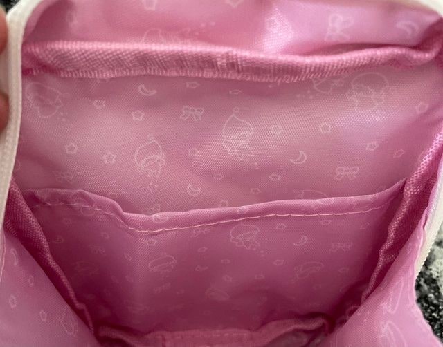 ポーチの内側。ピンクの裏地に妖精さんたちの柄プリントと内ポケットが確認できる
