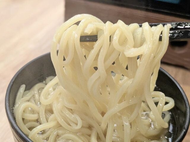 鳥取牛骨ラーメンの麺を箸で持ち上げた様子