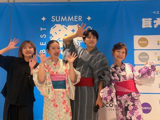 浴衣姿の3人とMCが手を振る様子