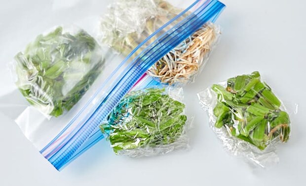 せりを冷凍用保存袋に入れている写真