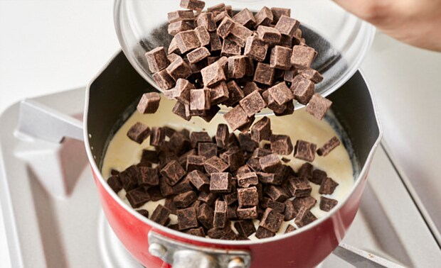 沸騰直前の生クリームにチョコを入れている写真