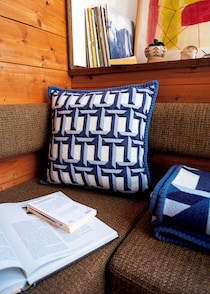 ひとつ置くだけで部屋がぐっと引き締まる、〈ティファニー〉のクッションとブランケット。