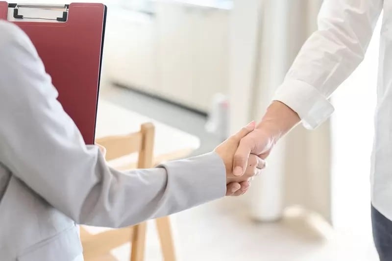 営業マンと握手して契約する