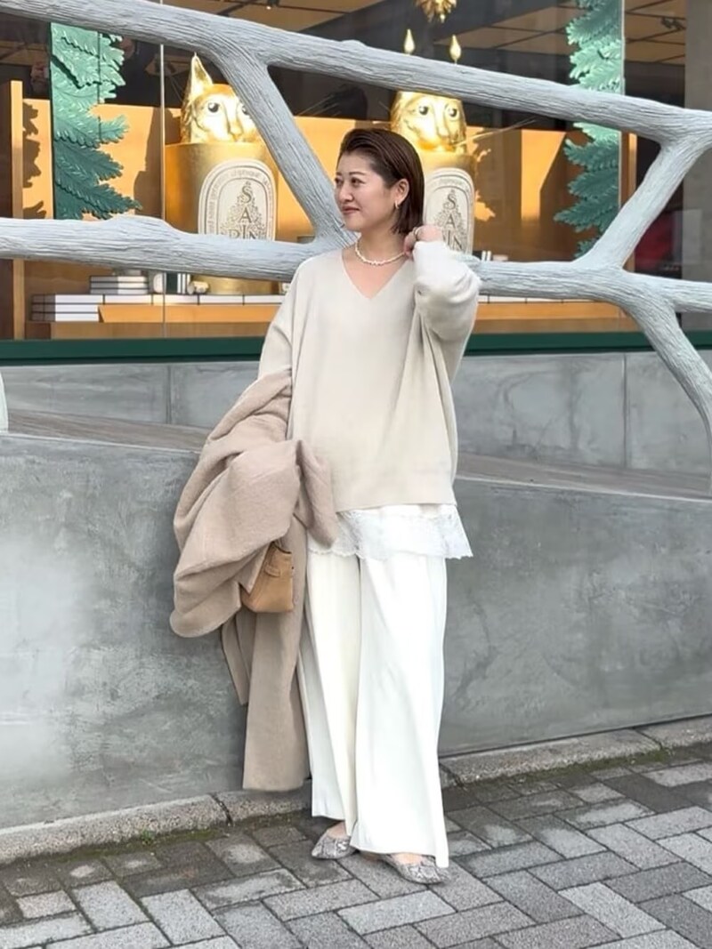 ニットの裾から旬のレースキャミをちら見せ