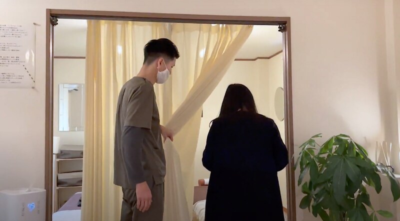 来院した患者を施術室へ案内する久保さん