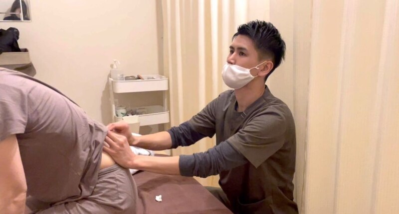 腰に鍼を刺した状態で前屈する様子