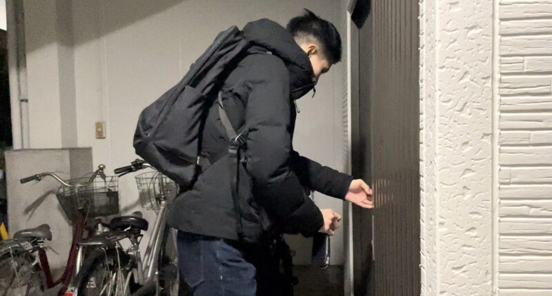 治療院の扉を施錠する久保さん