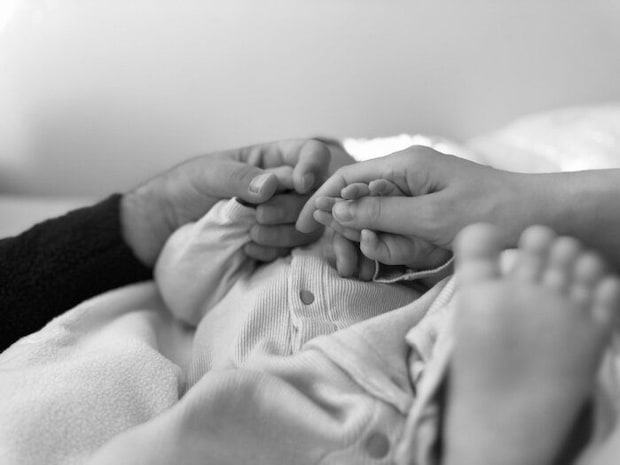 お子さんの手を握る、真風さんと勝矢さんのやさしい手。