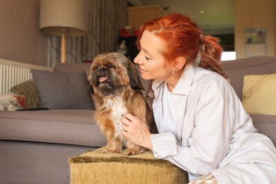 寄り添う飼い主と迷惑そうな犬