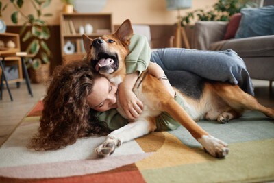 犬を後ろからハグする女性
