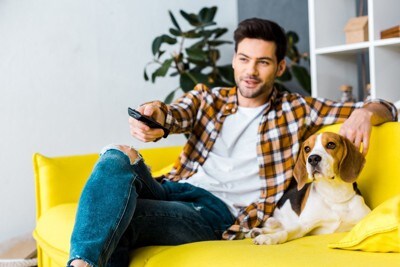 テレビを見ている男性と犬