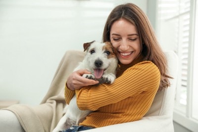 女性に抱っこされている子犬