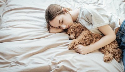 添い寝する女性と犬