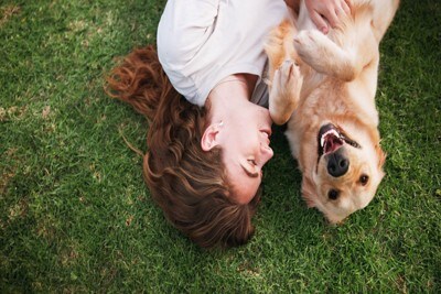 女性と寝転ぶ犬