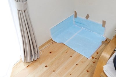 部屋の隅にトイレシーツを貼る