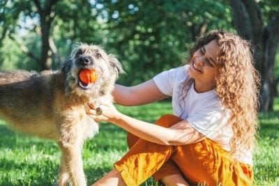 屋外で犬と遊ぶ女性
