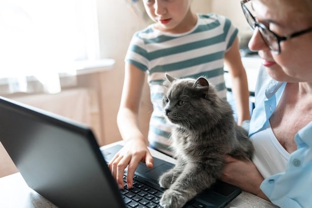 パソコンの前の親子と猫