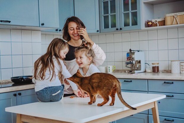 人間の親子とテーブルに乗る猫