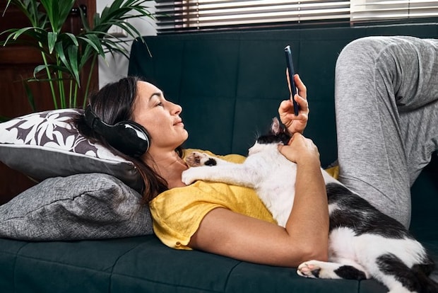 音楽を聴く女性と抱っこ希望の猫