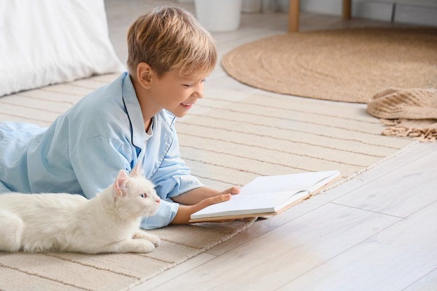 本を前にした猫と少年