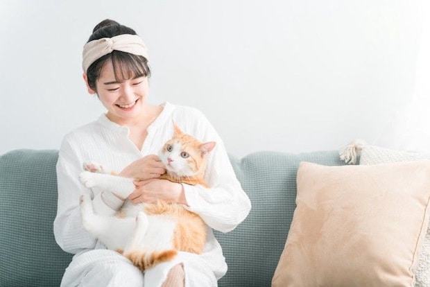 ソファで猫を抱える女性
