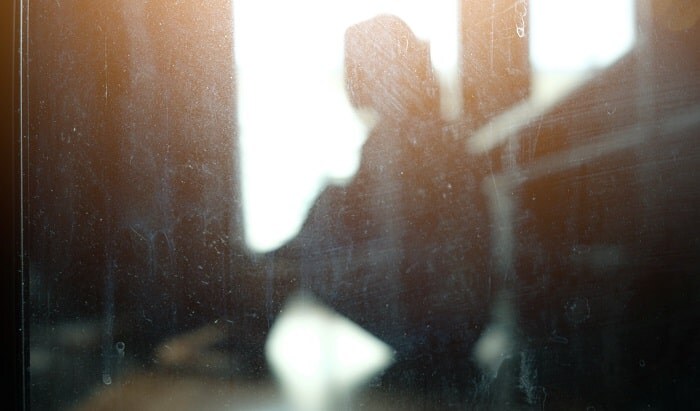 落ち込んで座り込む女性の影