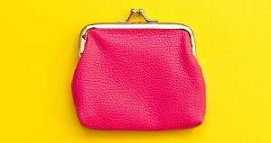 黄色いテーブルに置かれたピンク色のがま口財布