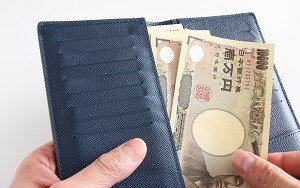 一万円札を財布に入れる