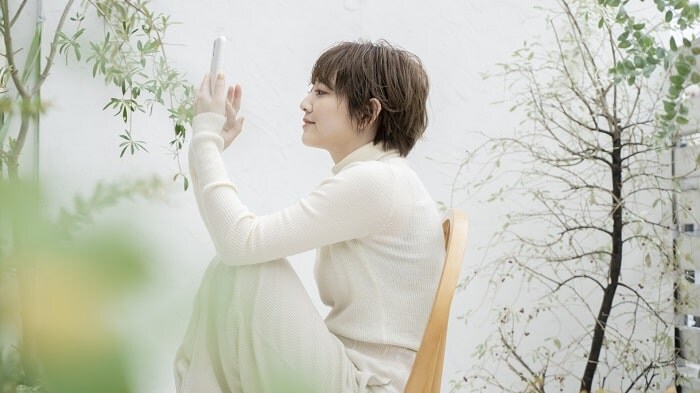 椅子にすわりスマホを扱う女性