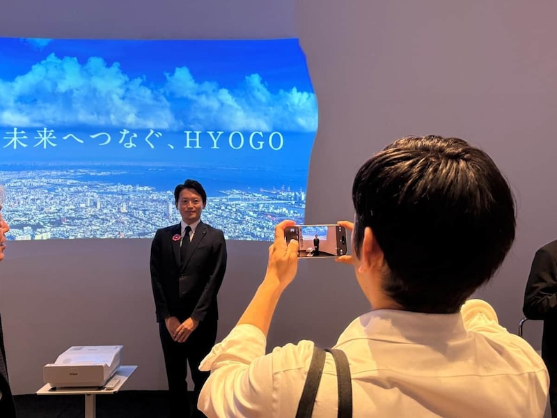 SNS投稿用とみられる写真を撮影する斎藤元彦知事(10月11日、大阪市此花区)