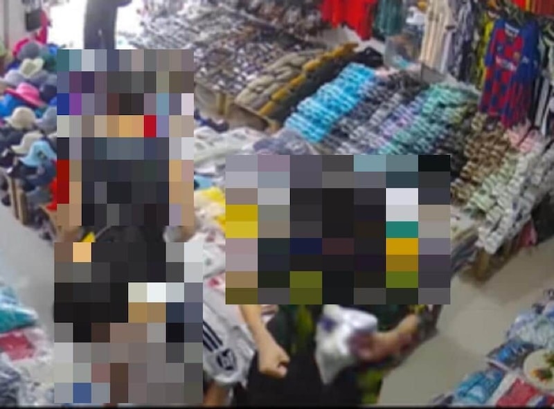 商品をバッグに突っ込む少年（右側、ネット投稿の動画から）